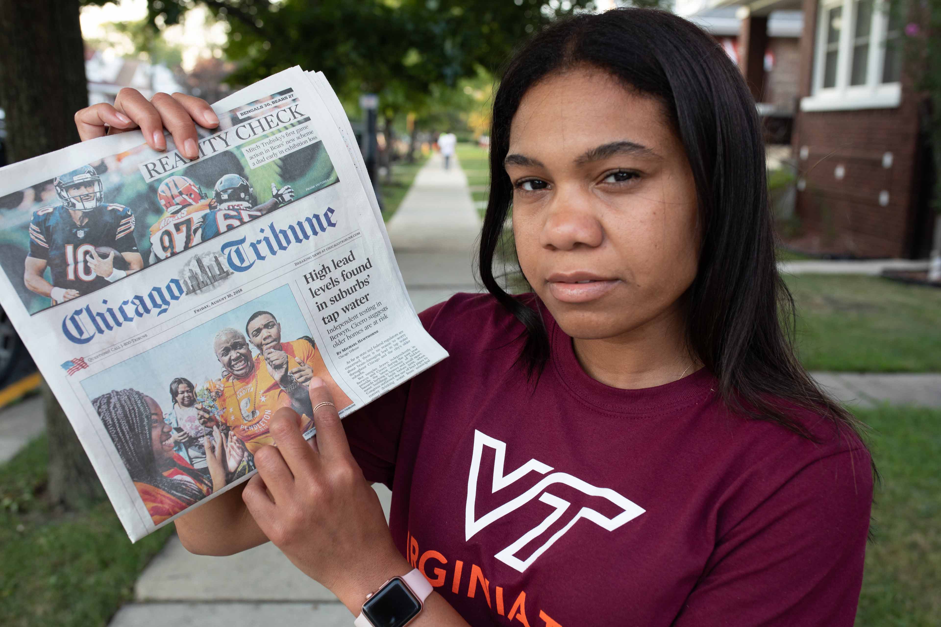 Chivonne Battle holding the Chicago Tribune with the water story on the cover.