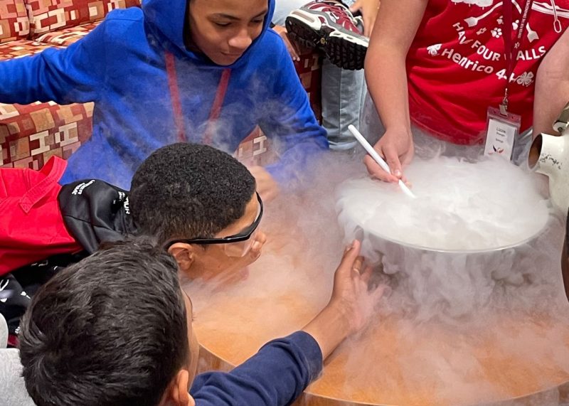 students looking at smoke coming out of a bowl