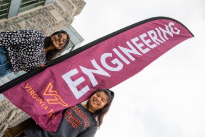 Two students stand by an Engineering banner.