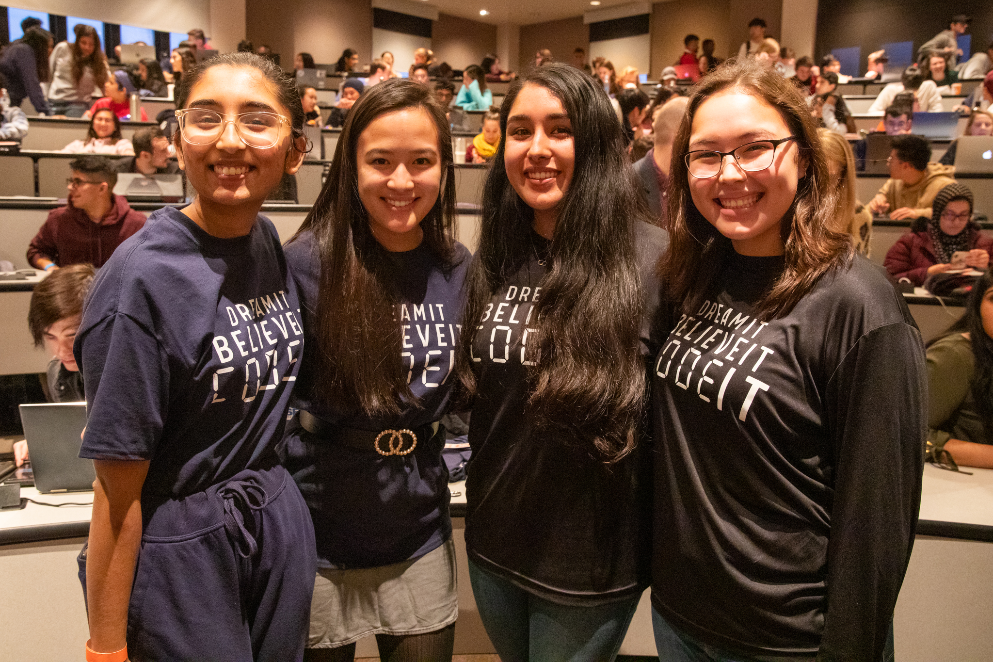 Four students stand for a group photo at a hacking event.