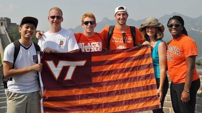 A group of Virginia Tech students holding a VT flag in the mountains abroad