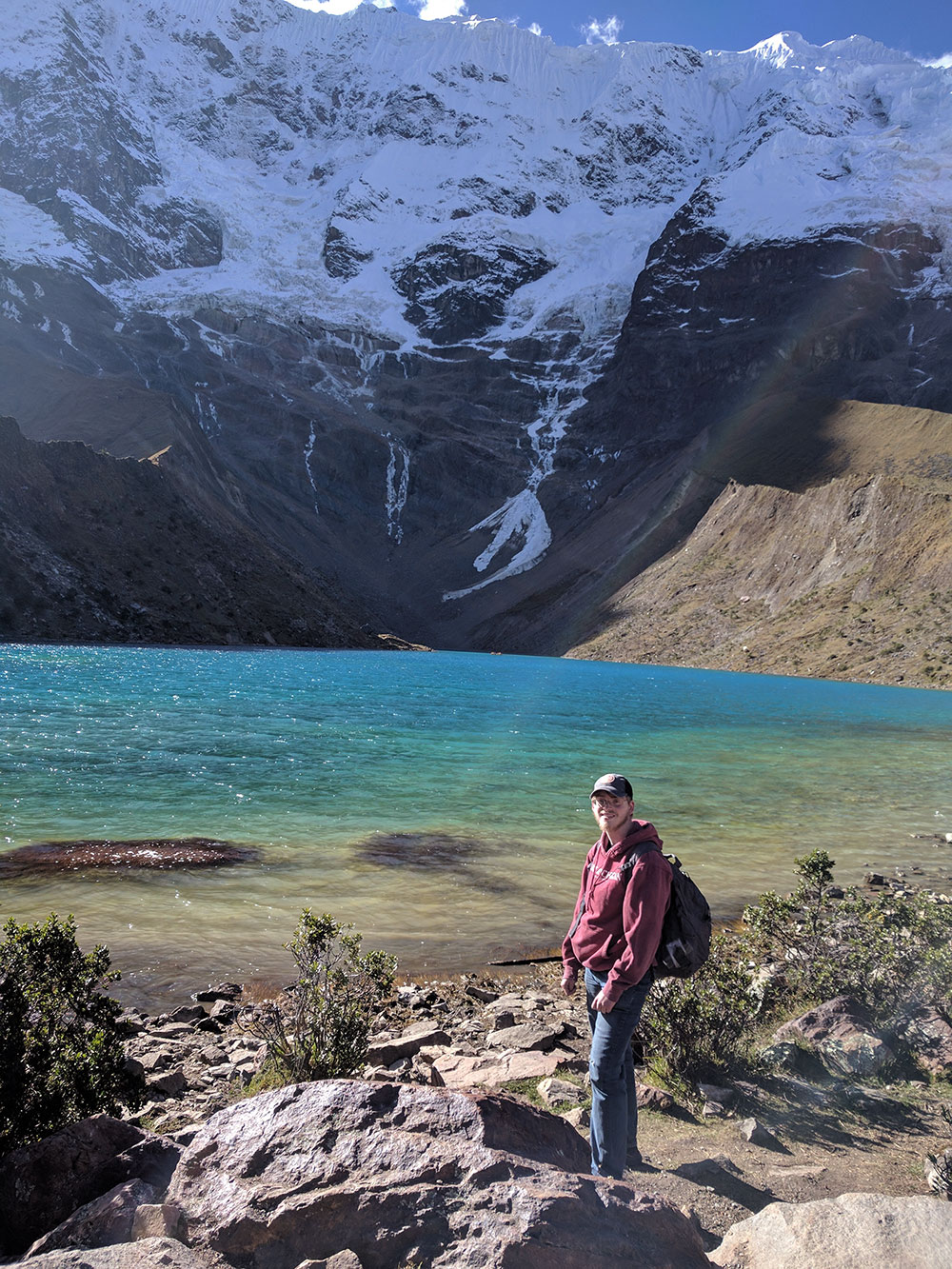 student standing by lake in the Andes