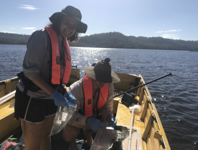 students taking water samples from boat