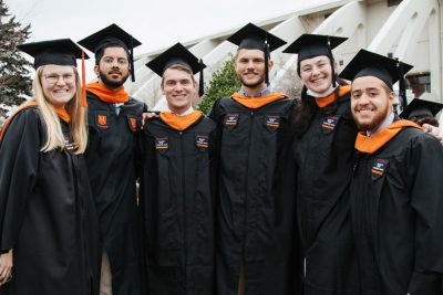 Graduate students pose for a group photo at commencement.