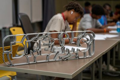 student working with metal sign