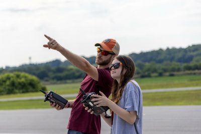 Girl flying drone with instructor.