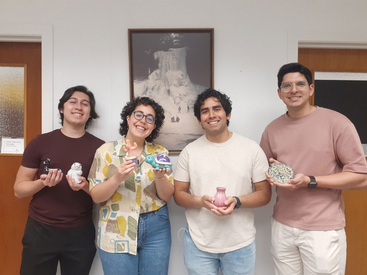 four students pose with their ceramic creations