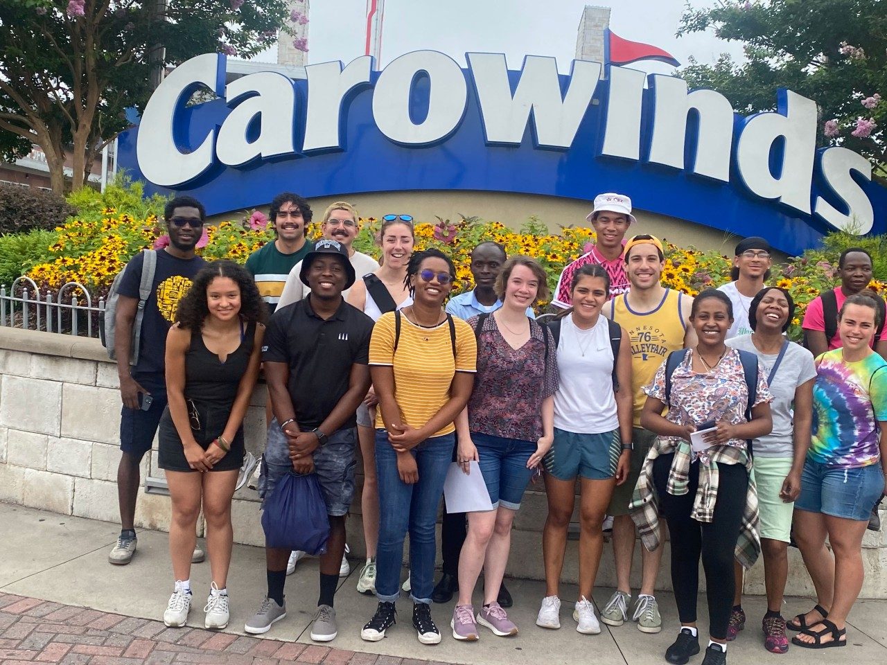 About 20 students pose together in front of the Carowinds sign