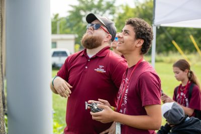 boy flying drone with instructor