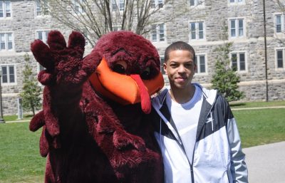 Hokie bird with arm around student