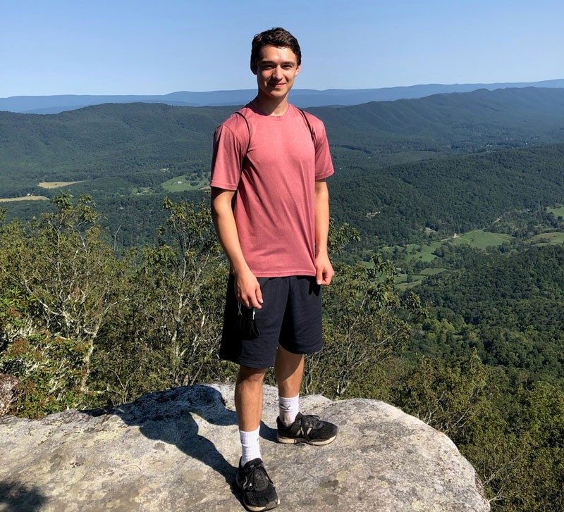 Jonathan West standing on a rock looking over the blue ridge mountains.