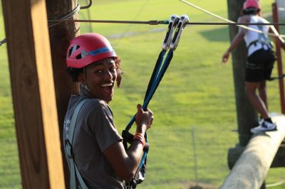 Student getting ready to go across a beam on the ropes course