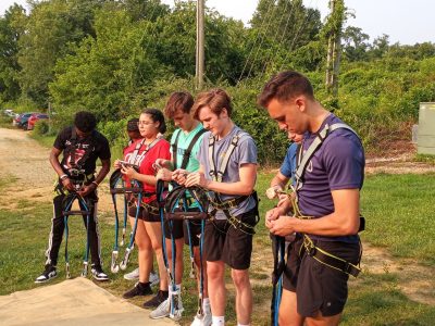 students prepare to go on the ropes course