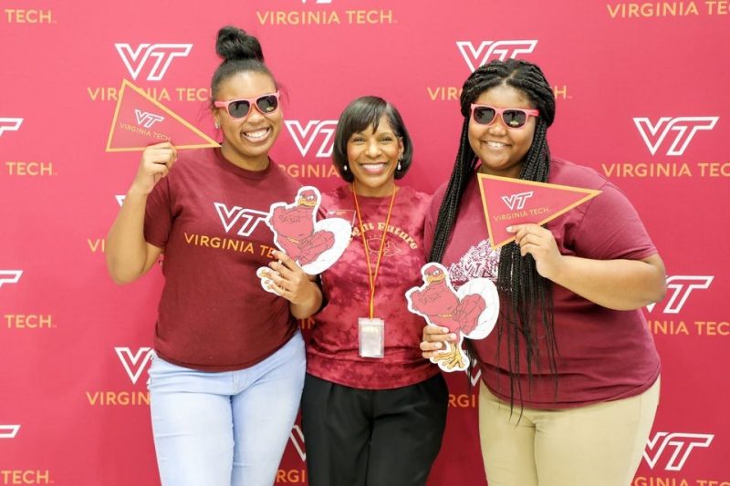 Three Black alumnae wearing Virginia Tech apparel. 