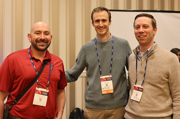 Three alumni at a conference