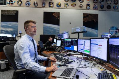 Garrett Hehn work at a flight desk at NASA