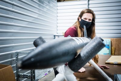 A female student works on a rocket in a lab