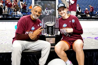 Women's basketball coach Kenny Brooks (at left) with Taylor Geiman and the ACC Championship trophy that the Hokies won in early March.