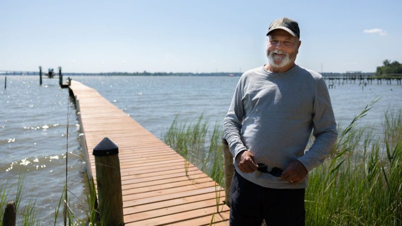 Dickie Youngk poses on the dock with the bay water in the background.