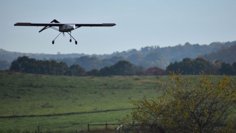 A drone flying over green fields.