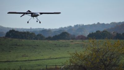 A drone flying over green fields.