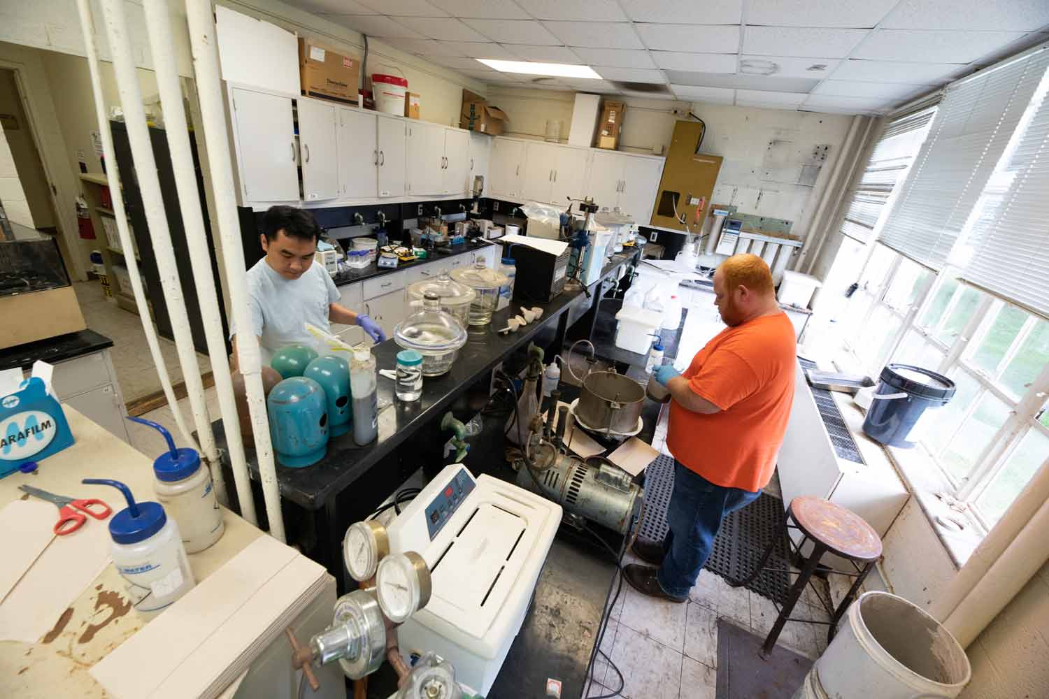 An outdated lab space in Holden Hall with two students working in crowded quarters. 