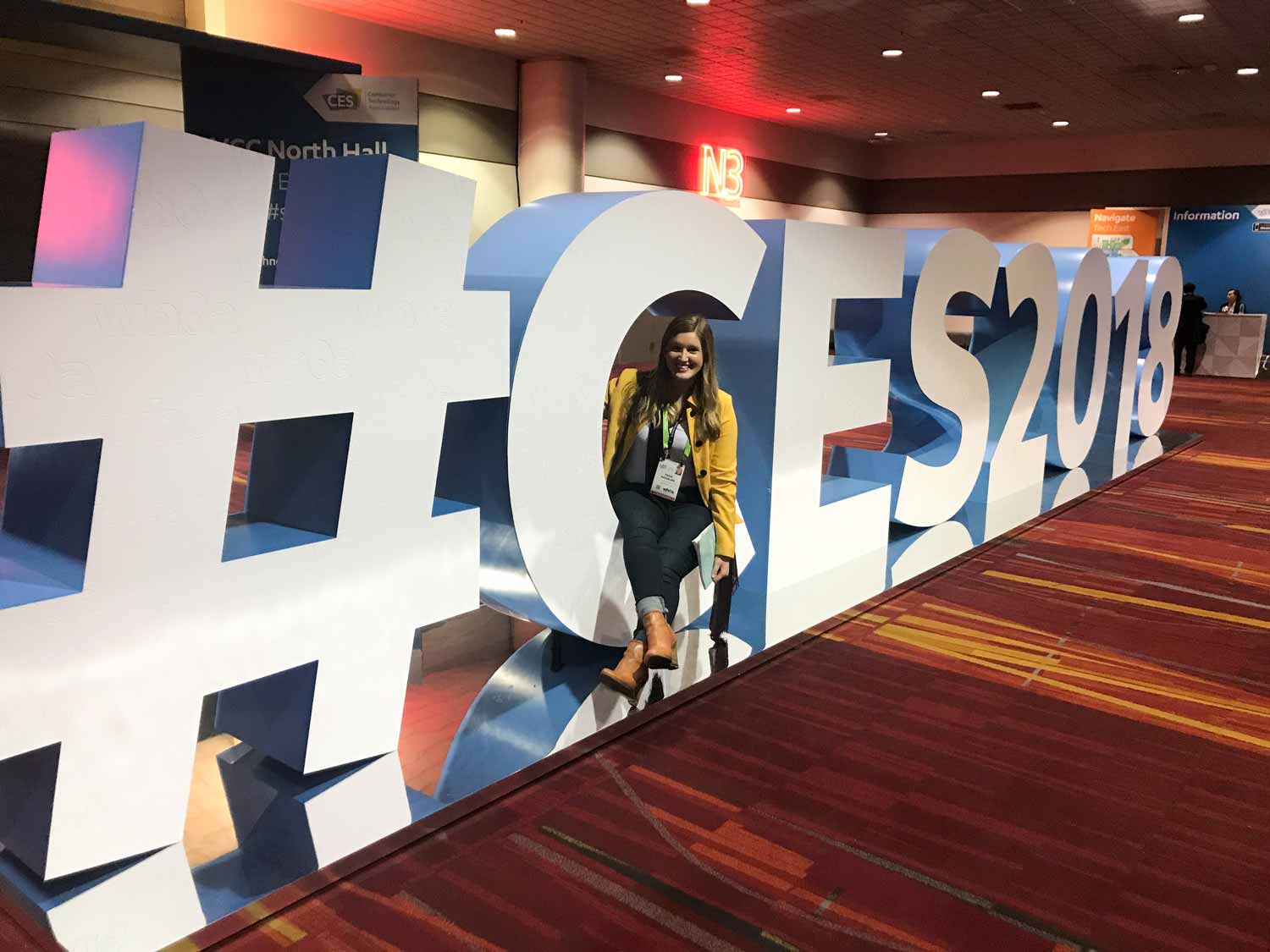 Paige Kassalen at CES2018 sitting in the hashtag logo display.