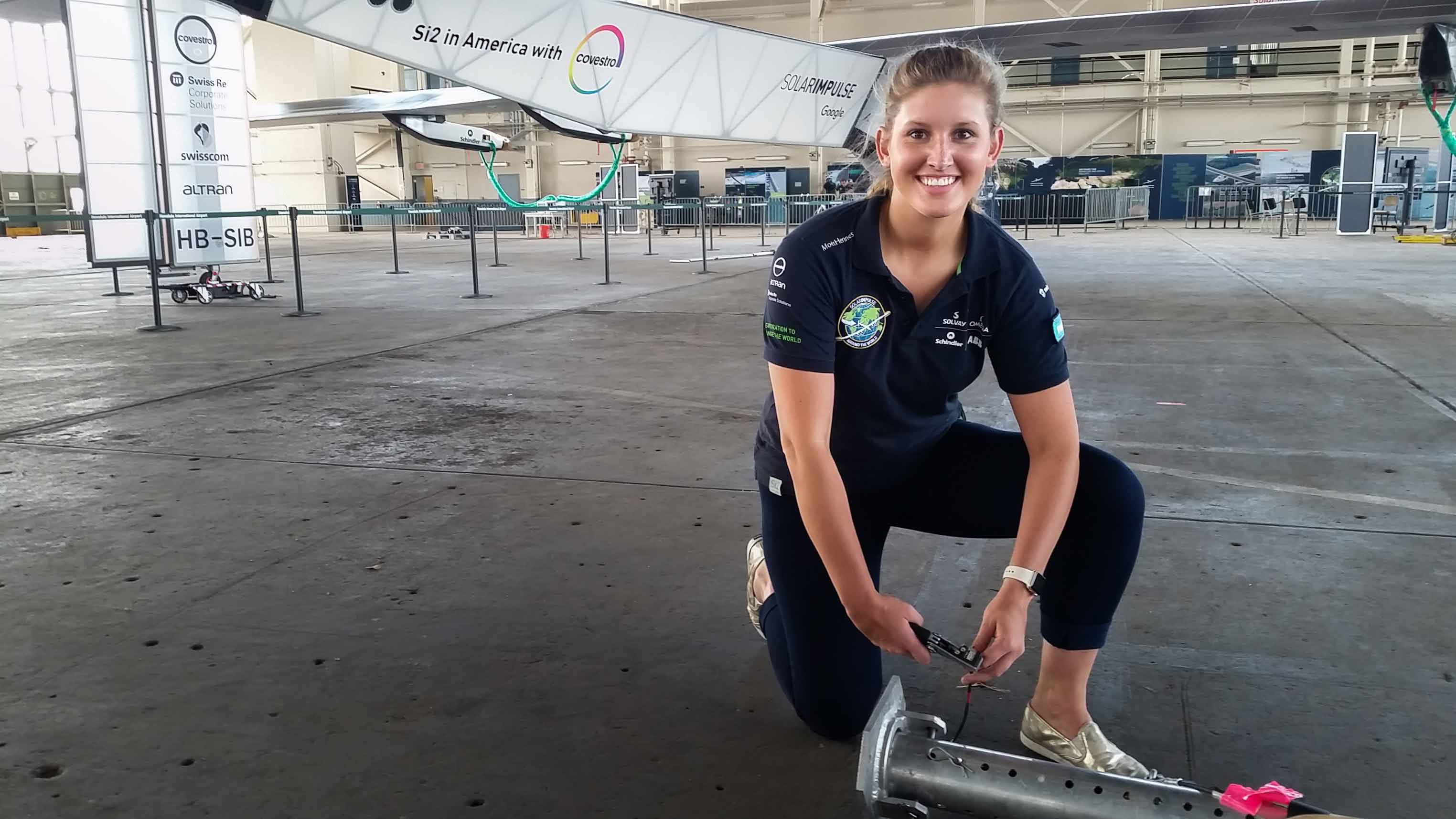 Paige Kassalen posing in a hanger in front of the Google Solar Impulse plane.