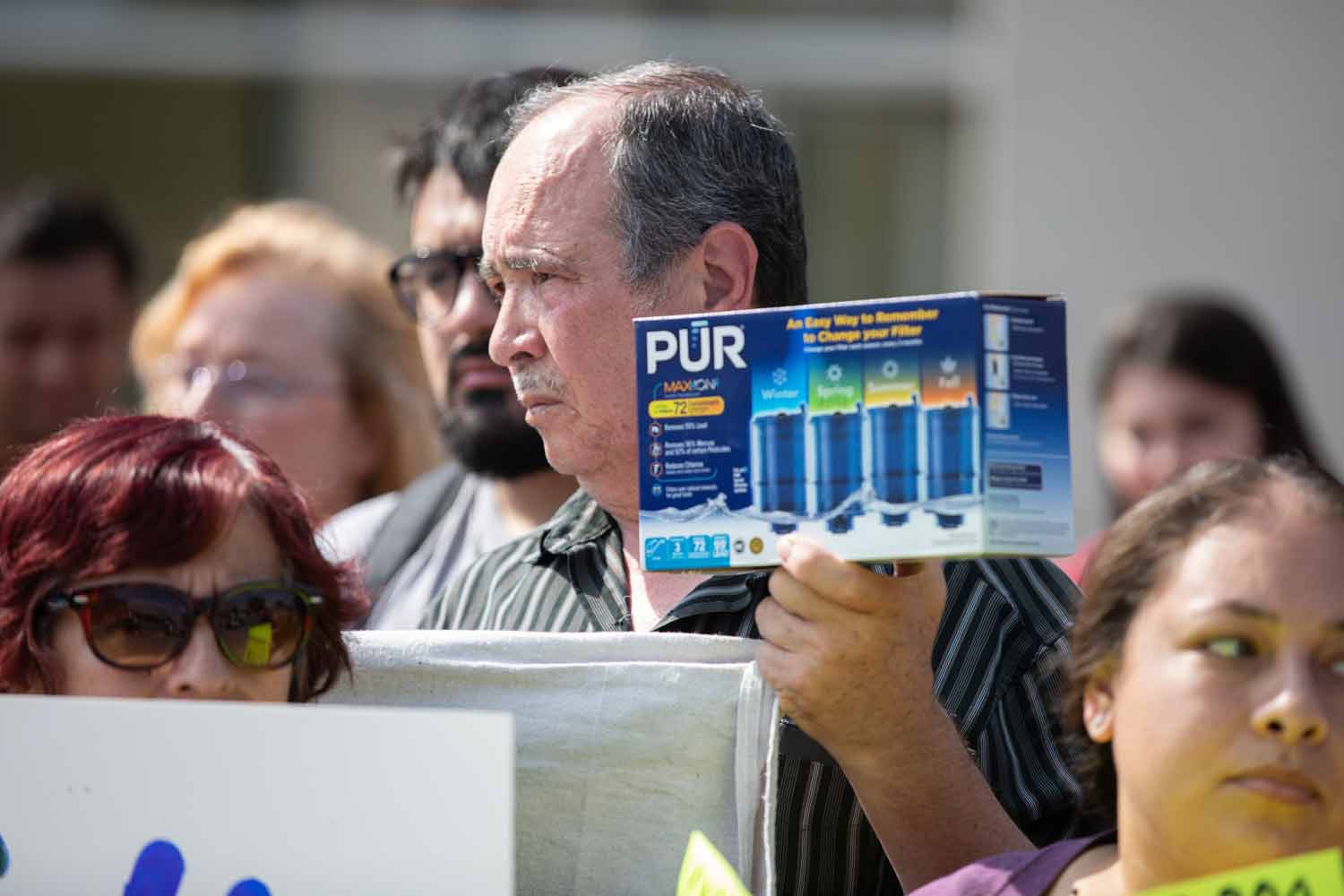 A man holds a PUR filter package to display at a Cicero IL water press conference.