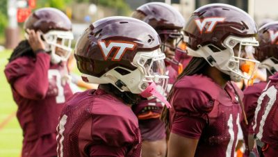 Virginia Tech football players with VT helmets on.