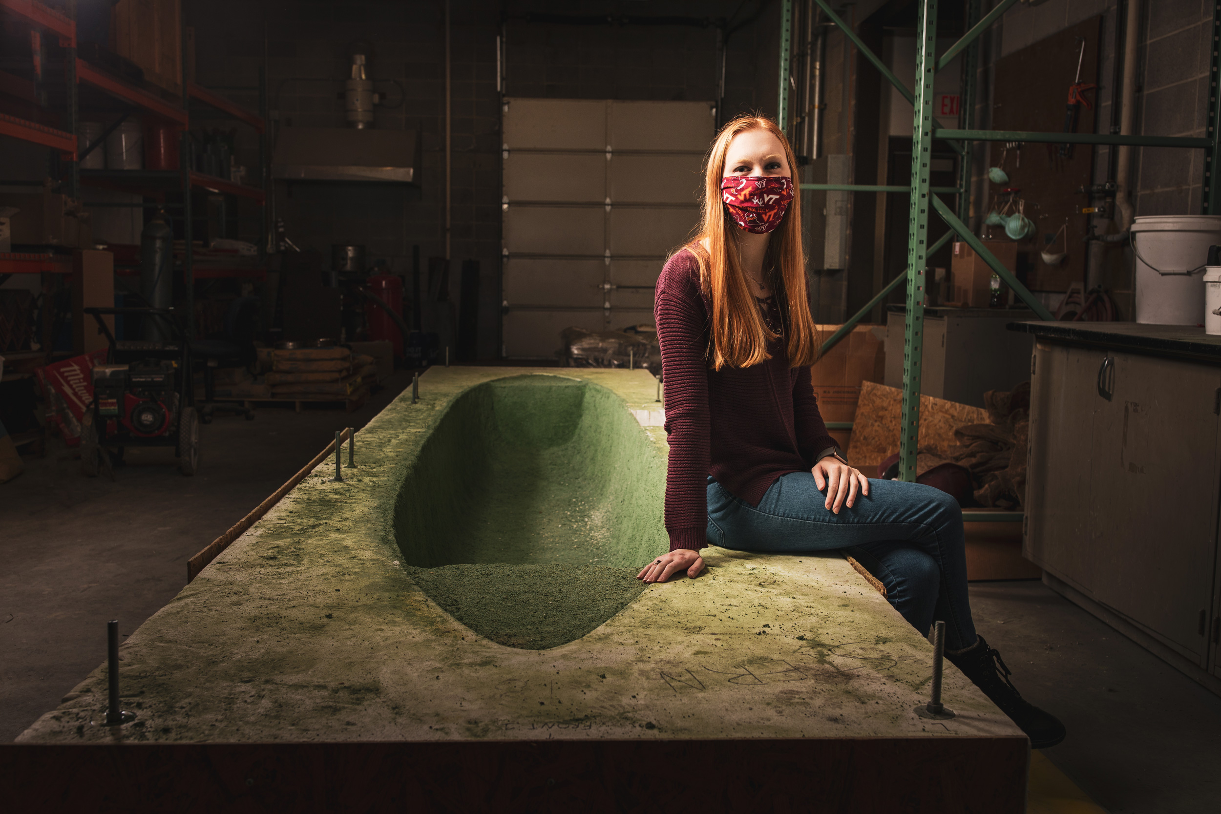 Jessica Viehman poses with the mold for the concrete canoe.