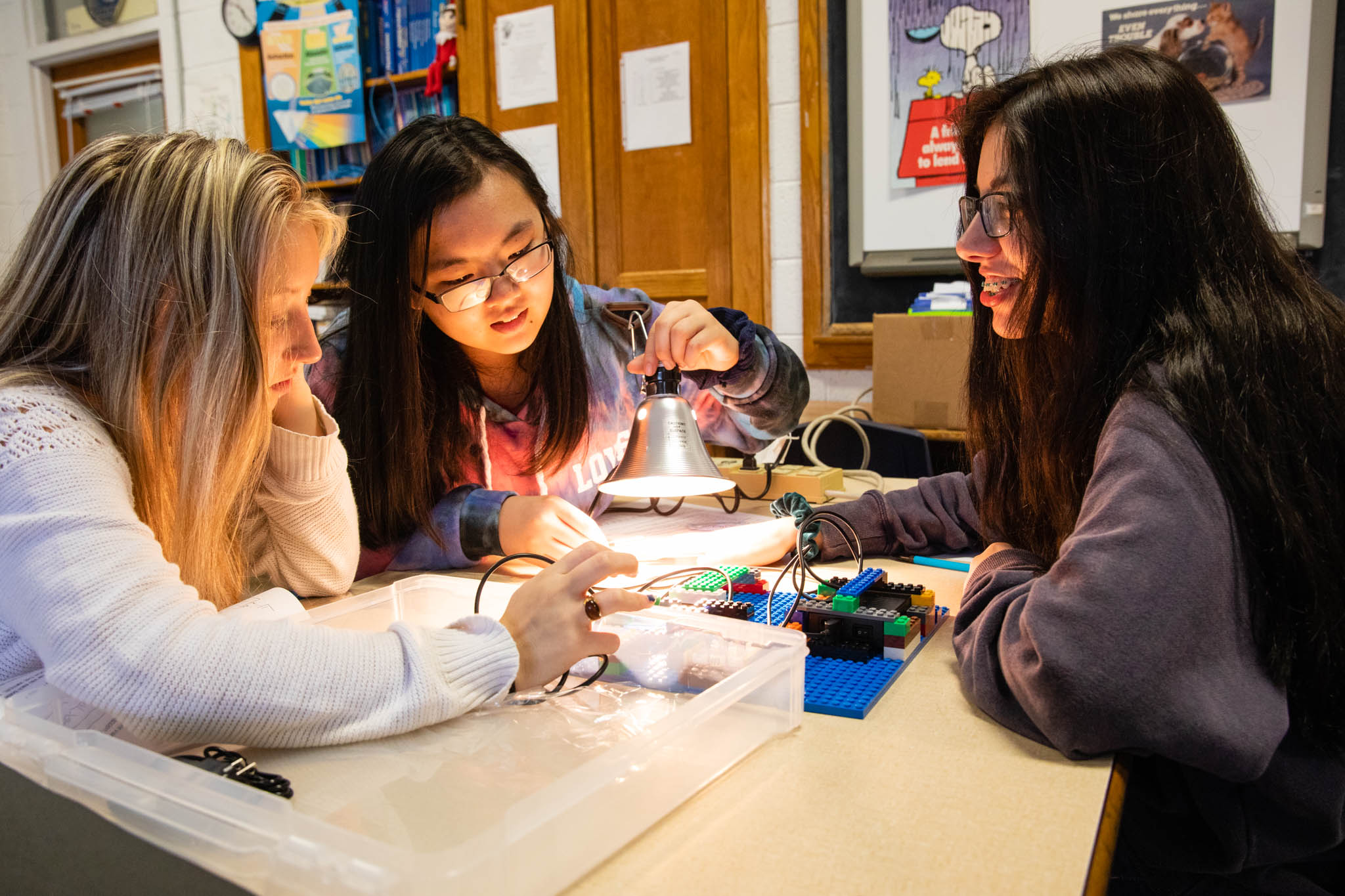 A groups of girl students work on a lego circuit board.