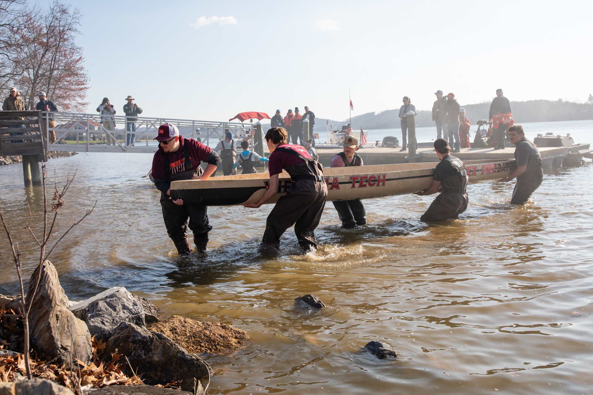 Team members lift the canoe out of the lake.