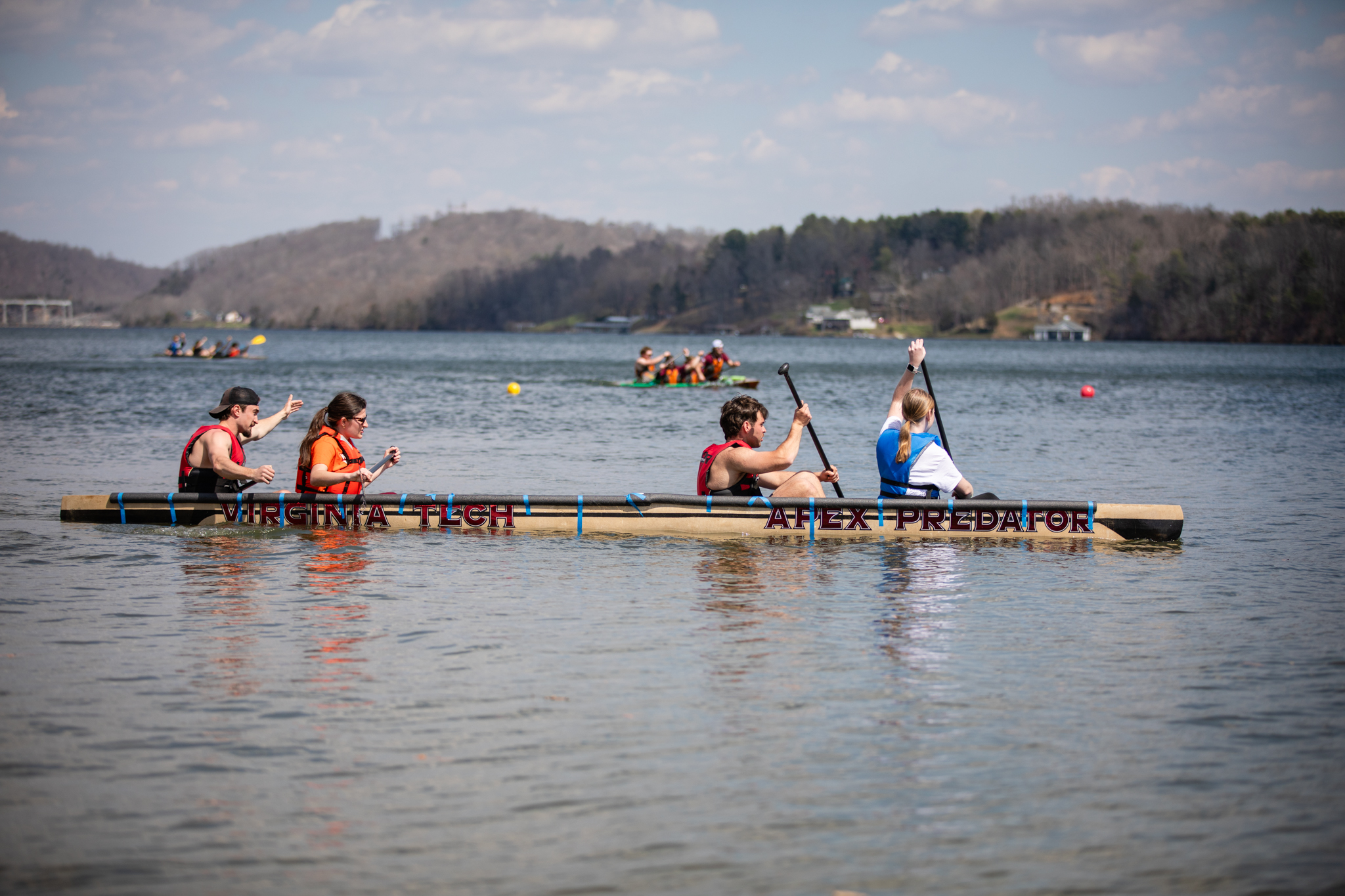 Concrete canoe team members paddle on the water during competition.