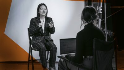 Xuan Wang being interviewed on a photo set.