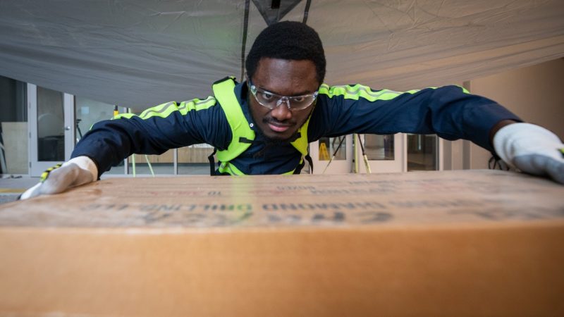 Evans Okyere, a master's student, lifts an item to test an exoskeleton.