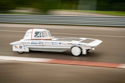 The solar car moving quickly on a track.