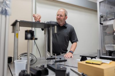 A man stands in front of a machine.