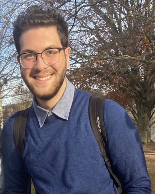 A male student wears glasses and a backpack.