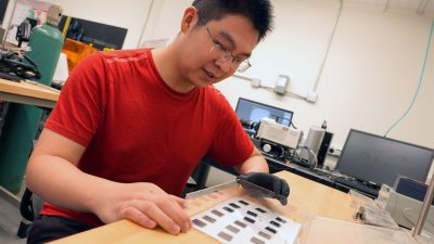 Wenge Huang inspects material samples in the lab of Jiangtao Cheng. Photo by Alex Parrish for Virginia Tech.