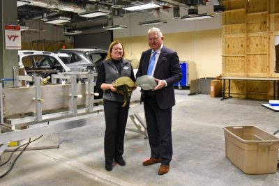 Pamela VandeVord (left) and Gunnar Brolinson (right) pose with helmets in a lab at the Edward Via College of Osteopathic Medicine