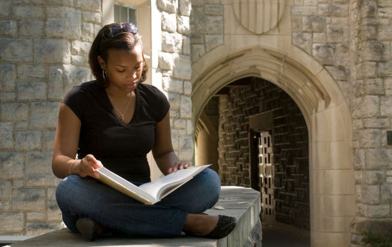 Student studying outside by arch