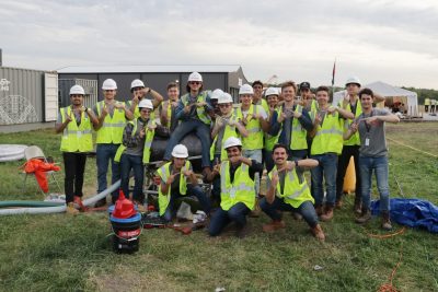 A team group photo with everyone in there yellow safety vests.