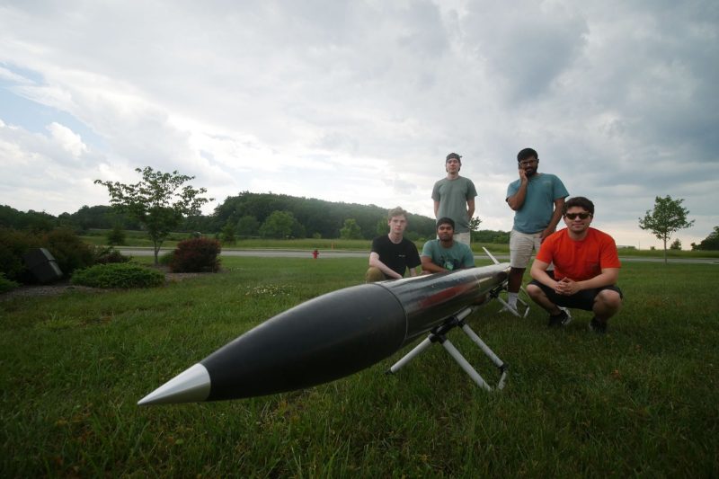 Students posing with a rocket.