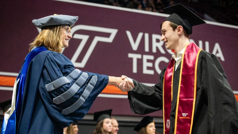 Undergrad student shaking the dean's hand.