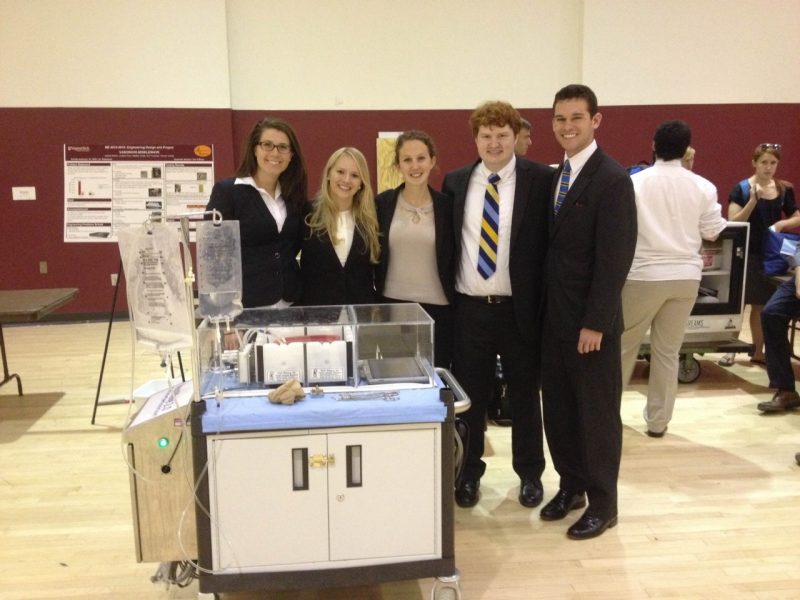 Wildman and her senior design team smiling behind a portable system that perfused an organ outside the body.