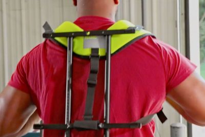 Back view of a worker were an A worker wearing an exoskeleton.