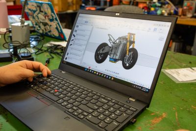 Laptop computer with a CAD drawing of a motorcycle on the screen.