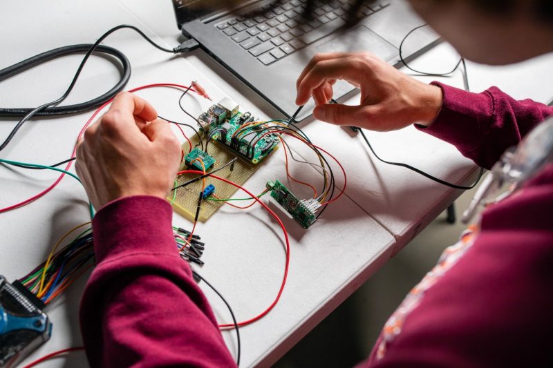 A student working on an electronic circuit.