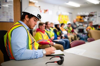 A student takes note while listening to a presentation about the construction of Hitt Hall.